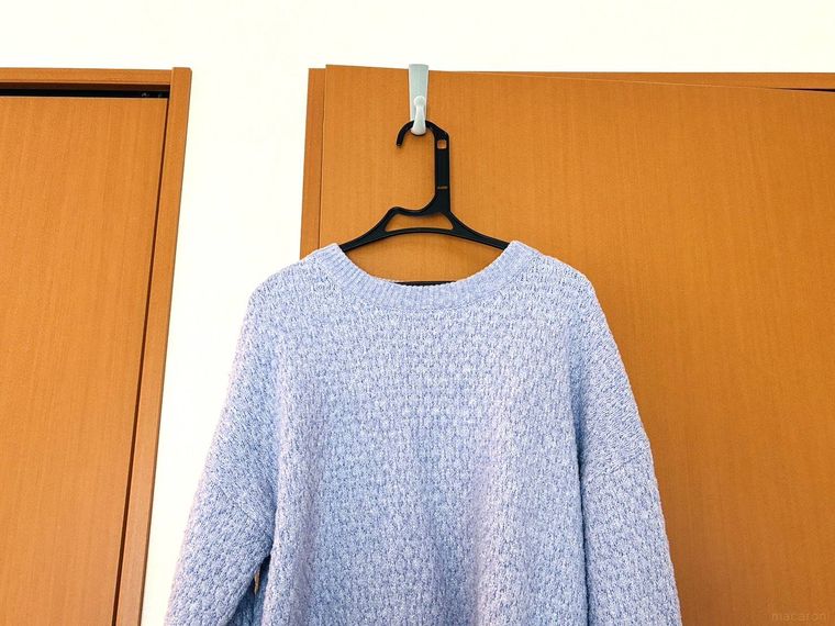 ハンガーに掛かったニットがドアフックに掛かっている