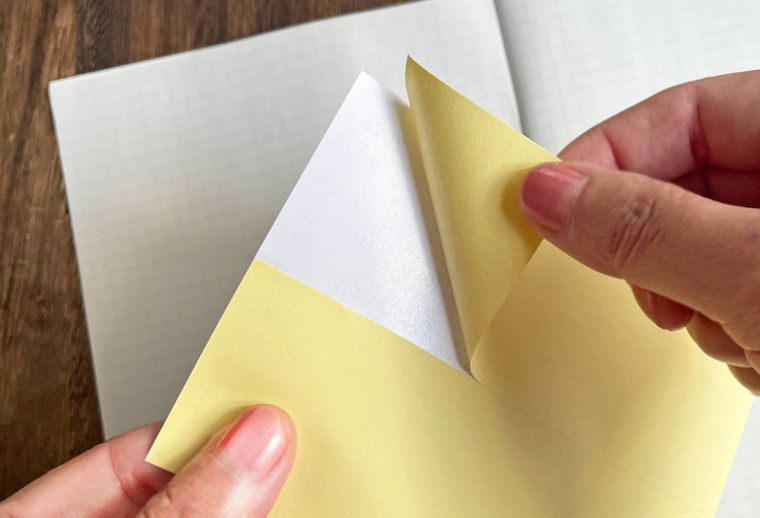 手でシールをめくっている写真