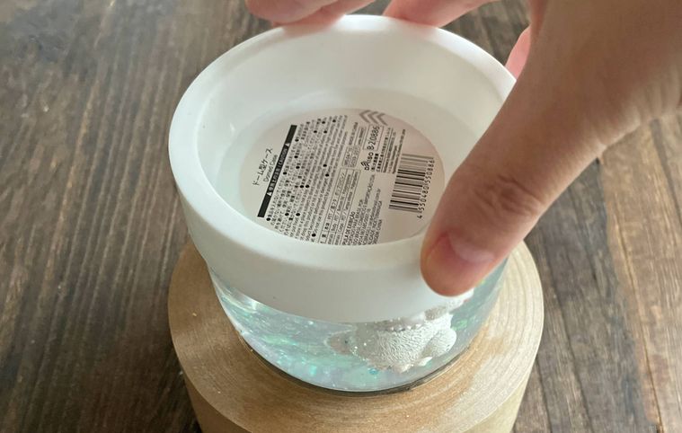 容器のフタを閉めている