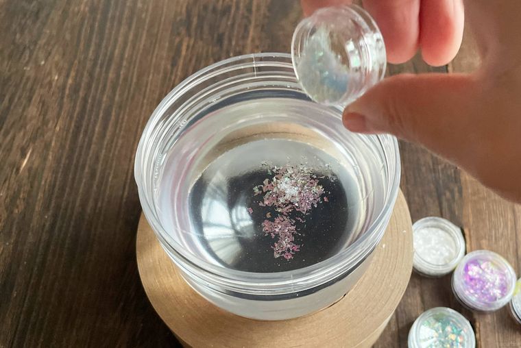 水を入れた容器にラメを投入している