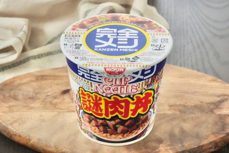 木のカッティングボードにのったカップの完全メシ謎肉丼