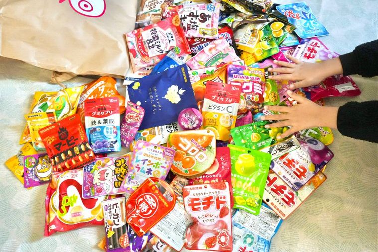 米袋に入った福袋の中身を開封する様子と子どもの手