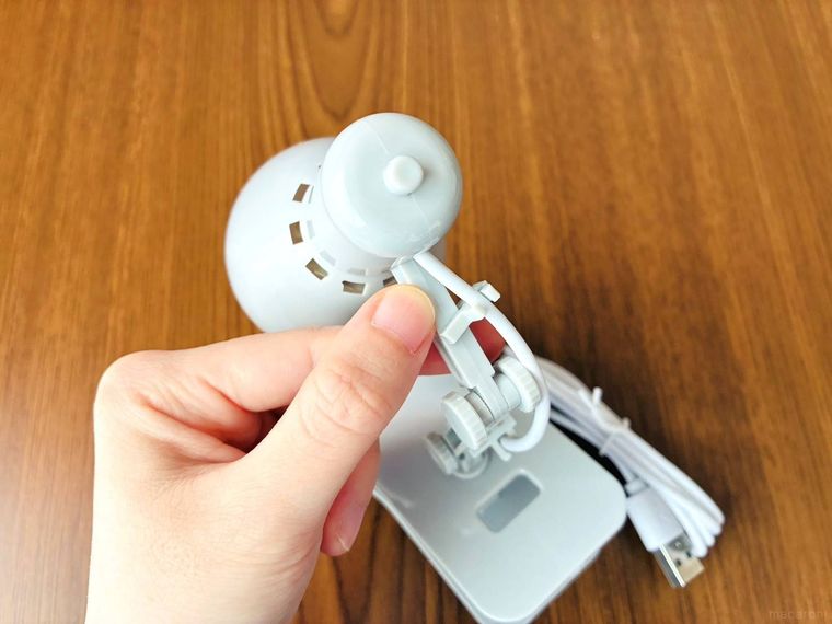 ダイソーのクリップライトのアームを手で曲げている