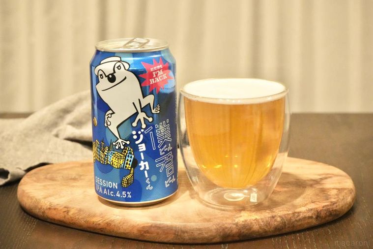 木のカッティングボードにのった青い缶のクラフトビールとビールが注がれたグラス