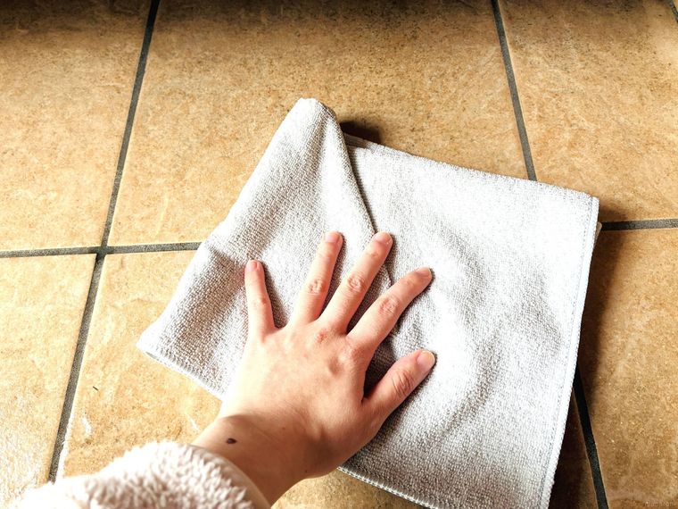 土間の水をマイクロファイバークロスで吸い取っている