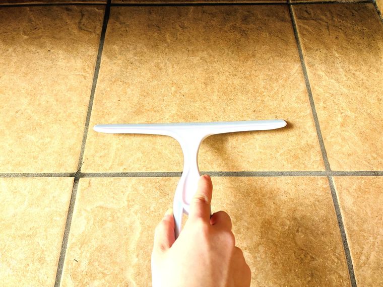 土間の水を水切りワイパーで取っている