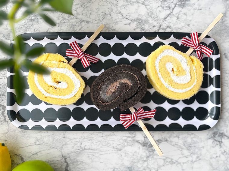 コストコの米粉のスイスロールをキャンディ状に棒に差し、ドット柄のトレーの上に3つ並べたところ