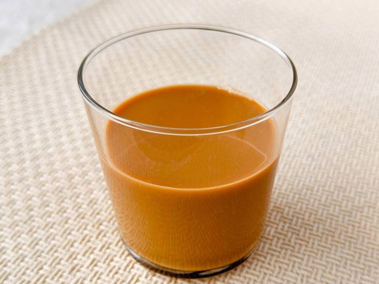 グラスに注いだ午後の紅茶The CREAMY TEA370gが置かれている様子