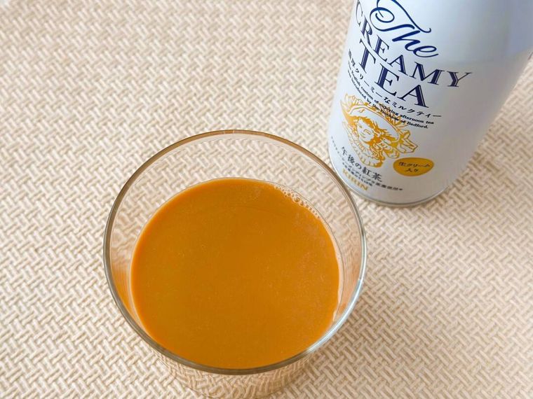 グラスに注いだ午後の紅茶The CREAMY TEA370gとパッケージが並べられている様子