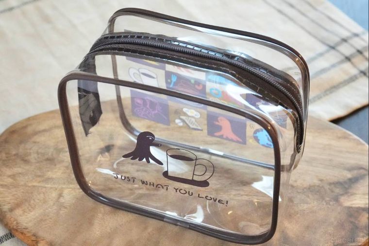 木のカッティングボードにのったイラストレーターデザインのクリアポーチ