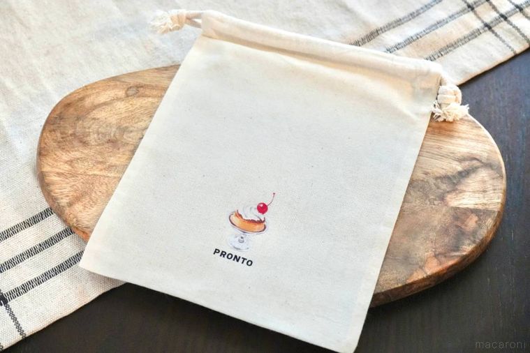 木のカッティングボードにのったコットンの生成色巾着