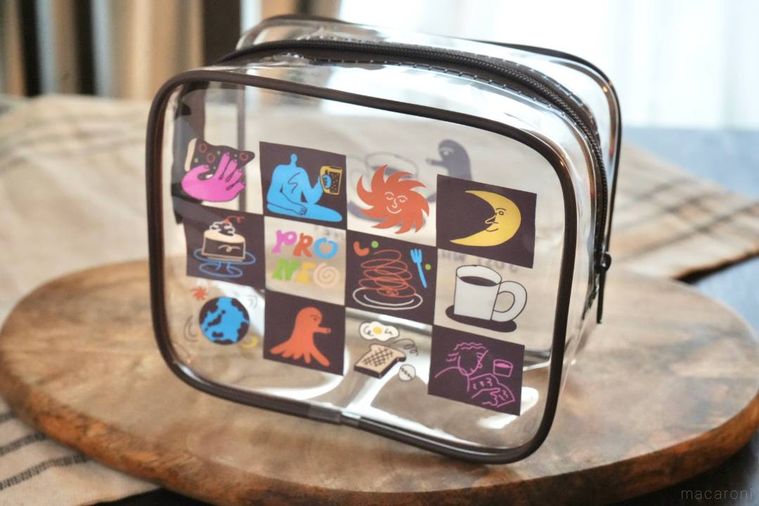 木のカッティングボードにのったイラストレーターデザインのクリアポーチ