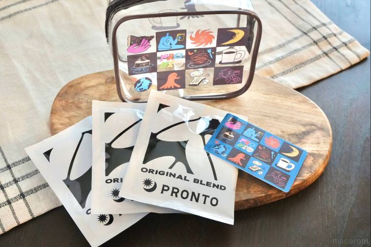 木のカッティングボードにのった福袋のクリアポーチとコーヒードリップバッグとギフトカード