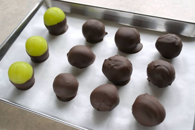チョコレートコーティングしたシャインマスカットがクッキングシートの上に並んでいる