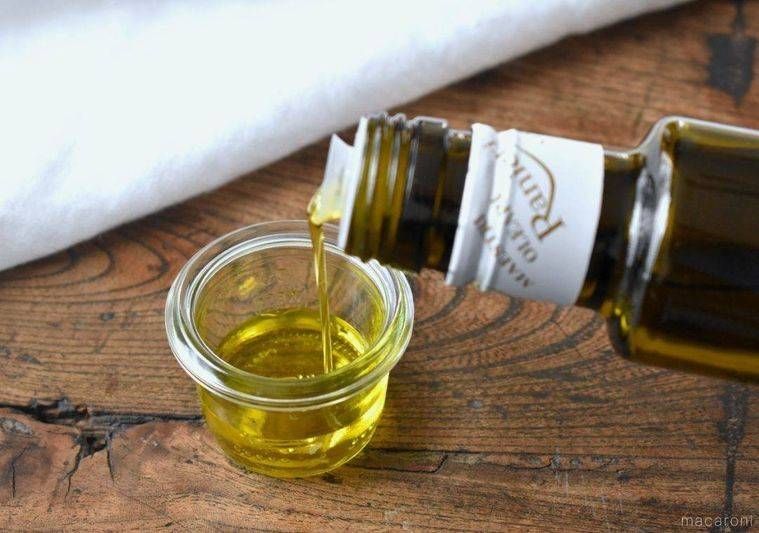 ガラス容器にオリーブオイルを注いでいる様子