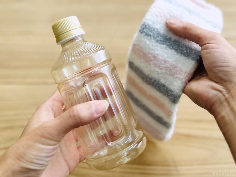 空のペットボトルとレッグウォーマーを手で持っている様子