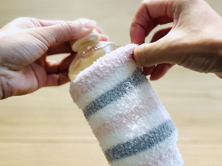 お湯が入ったペットボトルにレッグウォーマーをかぶせている様子