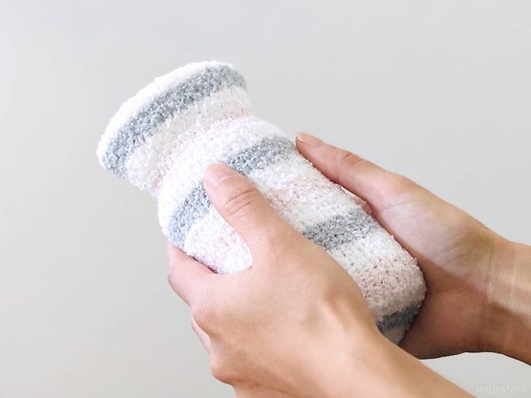 ペットボトル湯たんぽを両手で包んでいる様子