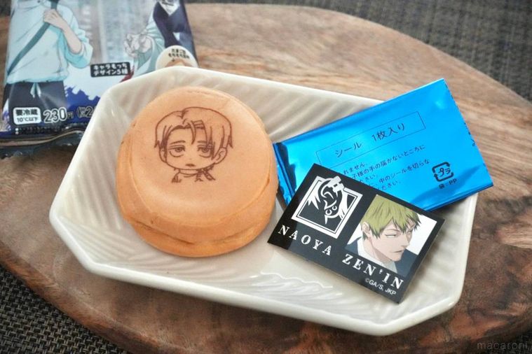 木のカッティングボードと白い皿にのったキャラクターデザインのスイーツとシール