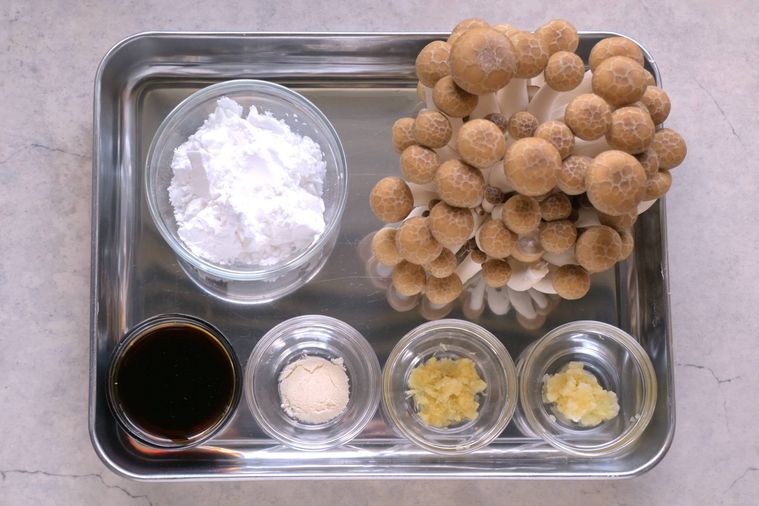 調理用バットに並べられたしめじ、にんにく、しょうが、片栗粉などのの唐揚げの材料
