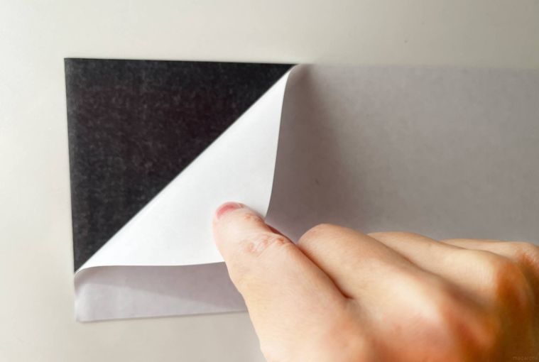 マグネットシートの粘着テープをめくっている様子