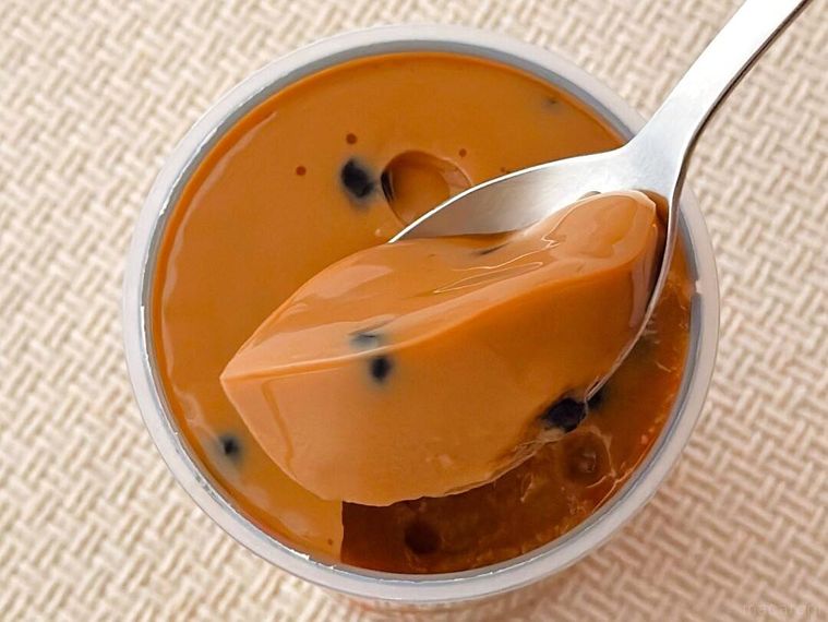 ドドンとタピオカミルクティープリンをスプーンですくっている様子