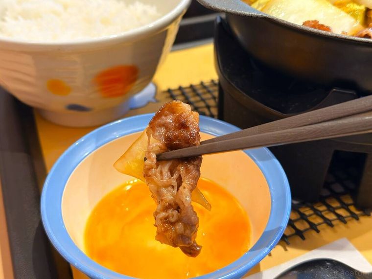 松屋 ちいかわのすき焼き鍋膳の牛肉を卵につけている様子