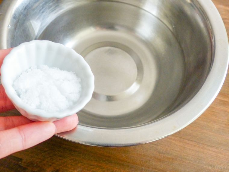 水を張ったボウルと塩を盛った手