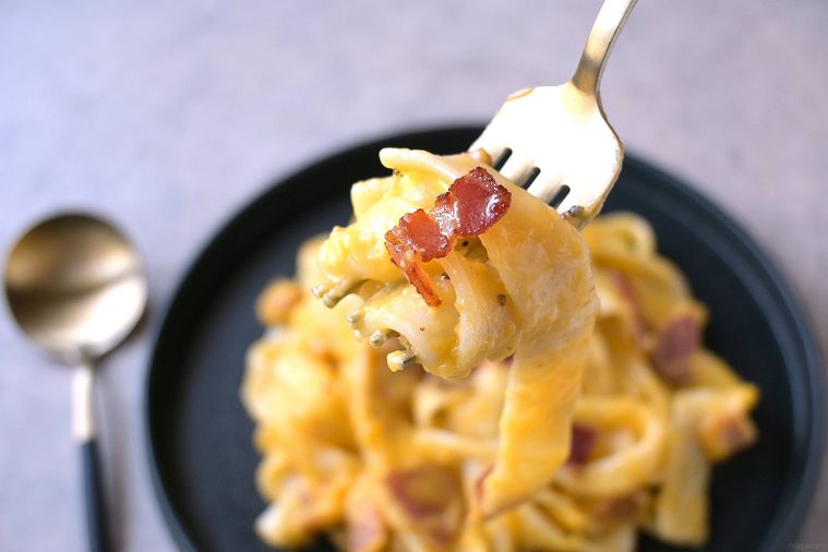 ほうとうカルボナーラをフォークで絡め取る様子