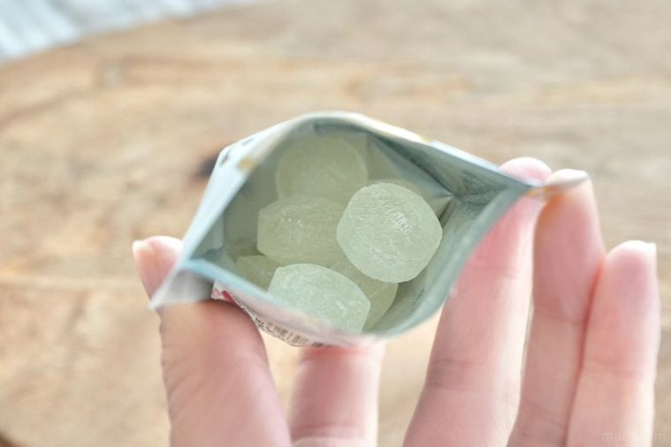 木のカッティングボードにのった白いパッケージのシュガーレスのど飴の袋の中身
