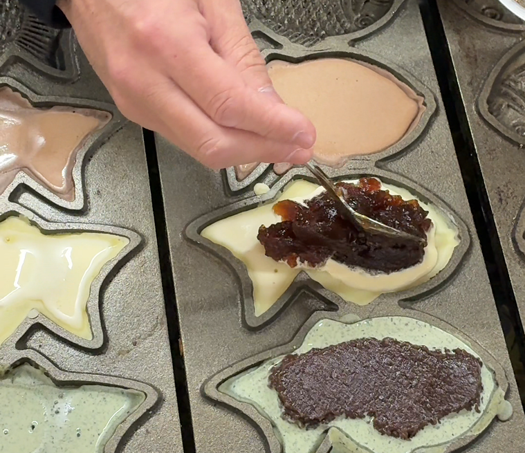 たいやきにみたらし餡を入れているところ