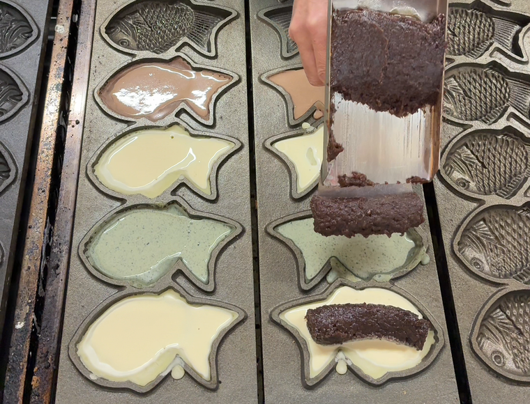 焼いているたいやきにあんこを乗せているところ