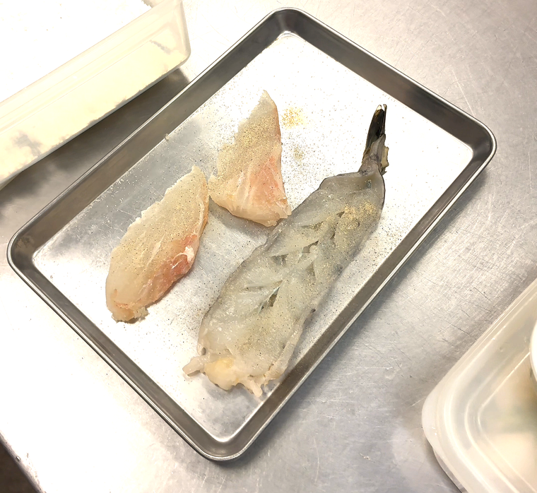 エビ・魚フライ定食の素材である白身魚の切り身と生のエビ