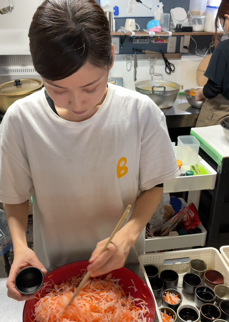 器に料理を盛っている濵田さん