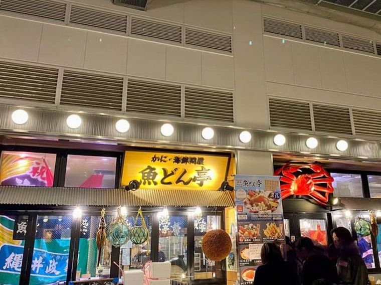 店頭に看板とかにのモニュメントが掲げられた魚どん亭の外観