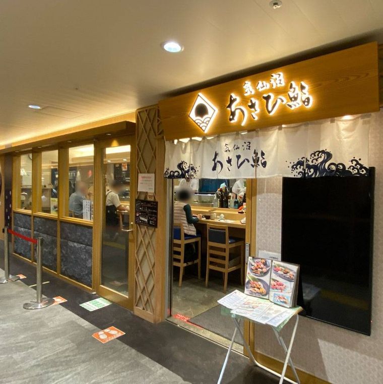 木の看板に白いのれんがかかった気仙沼 あさひ鮨 仙台駅店の外観