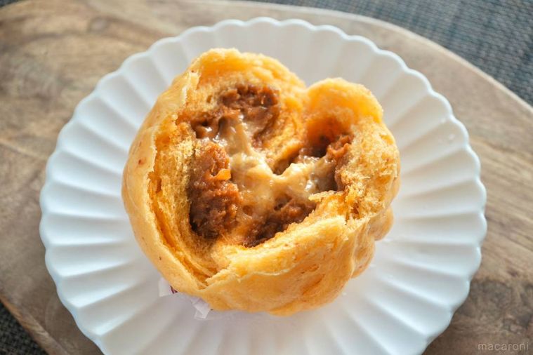 木のカッティングボードと白い皿にのった麻辣チーズまんの断面