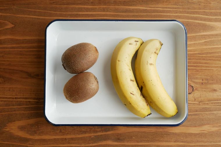 白い琺瑯バットの上に置かれたキウイとバナナ