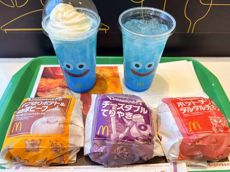 お盆にのせられた5種類のマクドナルドとドラゴンクのコラボバーガーやドリンク