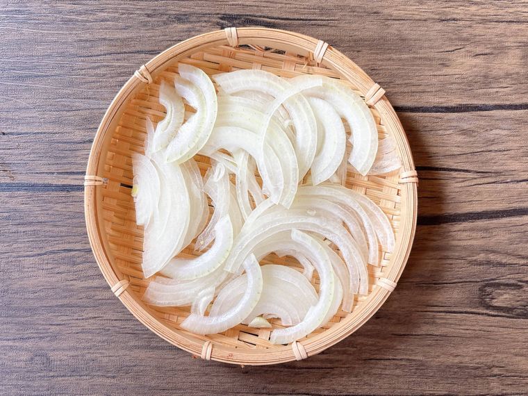 薄切りの玉ねぎをザルにのせて放置する様子