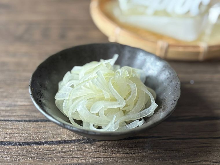 黒色の皿に盛られたはちみつ酢玉ねぎ