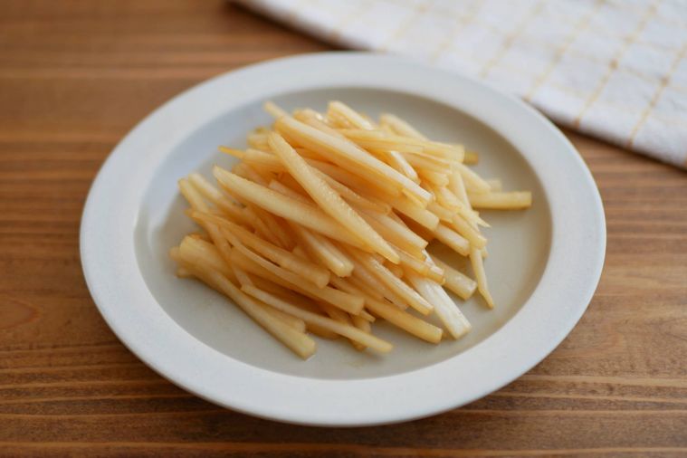 だいこんの皮のきんぴらが縁の白い皿に盛られている