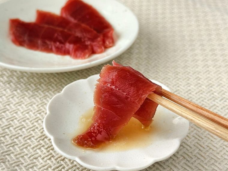 まぐろの赤身に金印純正ごま油と塩をたっぷりとつけている様子