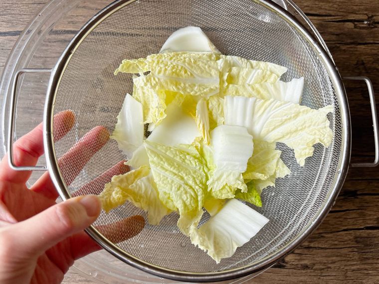 切った白菜をザルに入れて水からあげた様子