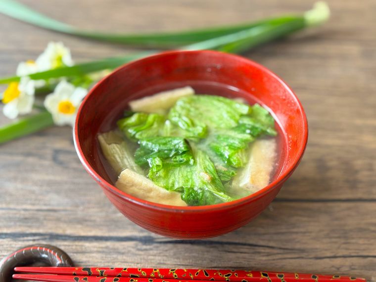 赤色の椀に盛られたレタスの外葉の味噌汁