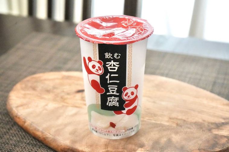 木のカッティングボードにのった紅白のドリンクカップパッケージの飲む杏仁豆腐