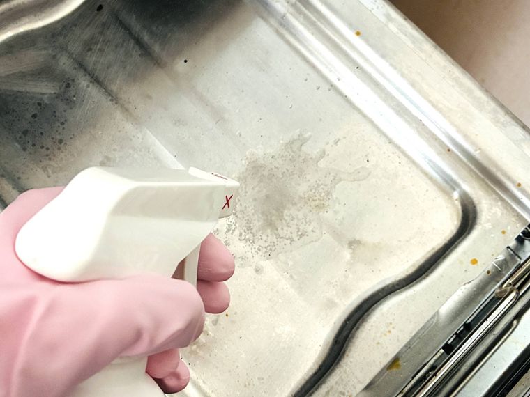 油汚れ・コゲ落としクリーナーを魚焼きグリルにスプレーしている