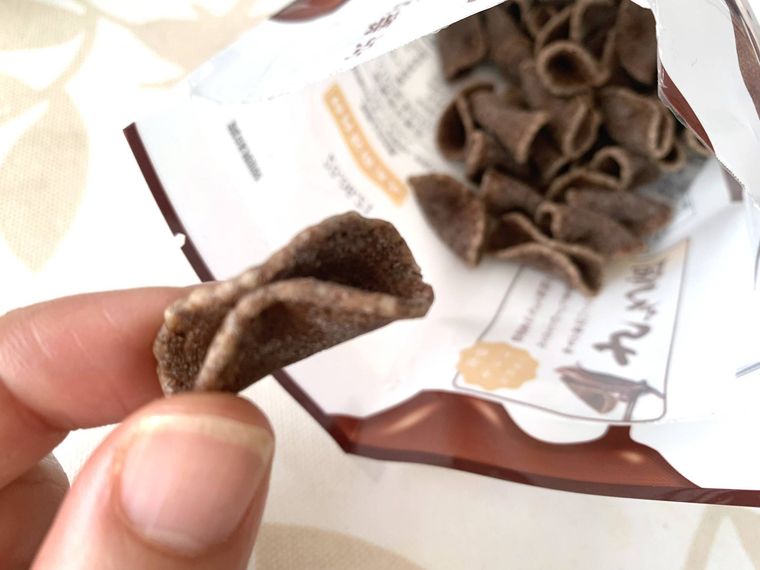 ちょこ煎のパッケージを開封して、ひと粒を手で持つ様子