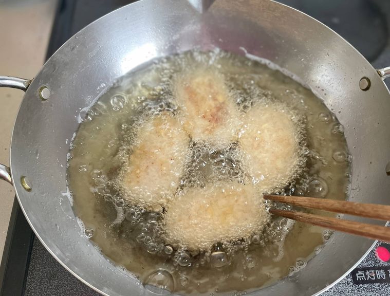 肉厚極旨とんかつを油で揚げている様子