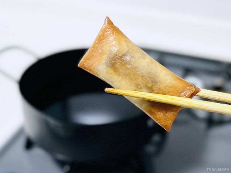 揚げたブラックサンダー春巻きを箸で持ち上げている様子